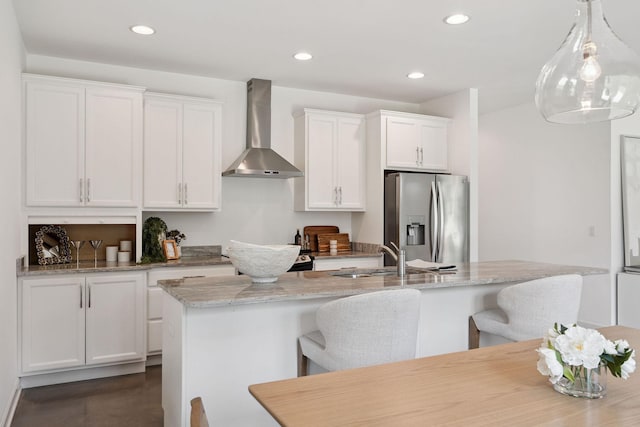 4711 Compassion Ln, Murfreesboro, TN 37128 - kitchen featuring stainless steel refrigerator with ice dispenser, wall chimney exhaust hood, a kitchen breakfast bar, white cabinets, and an island with sink