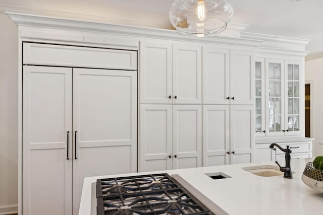 2000 Far Fara Way, Brentwood, TN 37027 - kitchen with white cabinetry, stainless steel gas cooktop, light countertops, glass insert cabinets, and ornamental molding