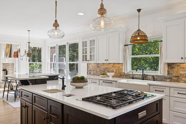 2000 Far Fara Way, Brentwood, TN 37027 - kitchen featuring stainless steel gas cooktop, white cabinets, light countertops, dark brown cabinets, and ornamental molding