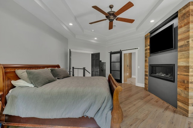 3120 Boxley View Ln, Franklin, TN 37064 - bedroom featuring light wood-style flooring, a barn door, recessed lighting, a tray ceiling, and ceiling fan