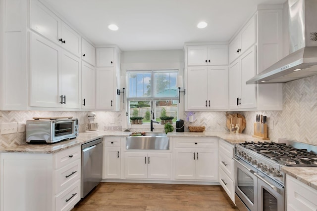 332 Country Club Rd, Winchester, TN 37398 - kitchen featuring wall chimney range hood, appliances with stainless steel finishes, backsplash, white cabinetry, and light stone countertops