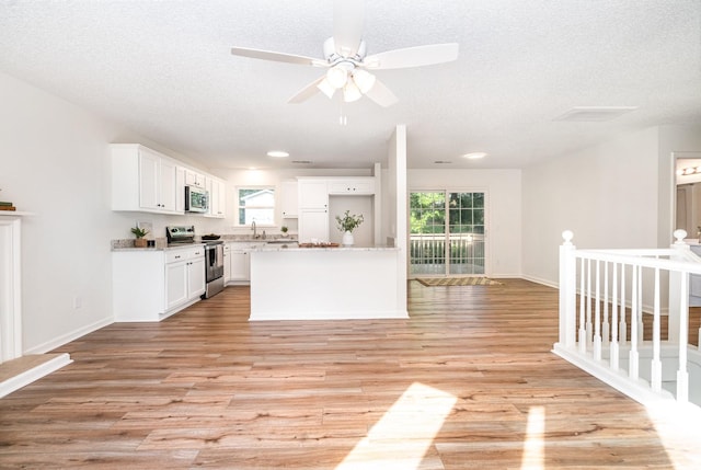 1204 Lambeth Way, Antioch, TN 37013 - kitchen with stainless steel appliances, a ceiling fan, a textured ceiling, white cabinets, and light wood-type flooring