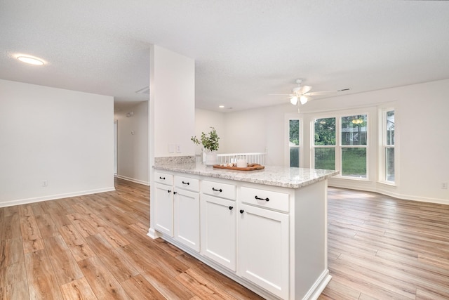 1204 Lambeth Way, Antioch, TN 37013 - kitchen with ceiling fan, light wood finished floors, white cabinets, light stone counters, and a peninsula