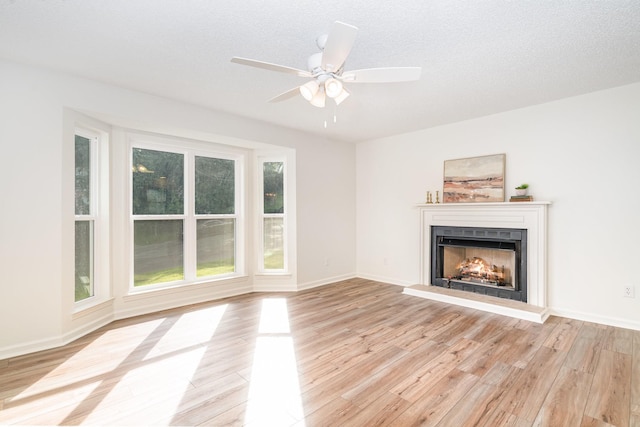 1204 Lambeth Way, Antioch, TN 37013 - unfurnished living room featuring a fireplace with raised hearth, light wood finished floors, and a ceiling fan