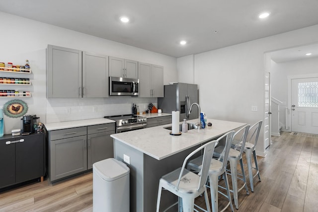 622 Birdie Dr, Spring Hill, TN 37174 - kitchen featuring appliances with stainless steel finishes, gray cabinetry, light wood finished floors, backsplash, and recessed lighting