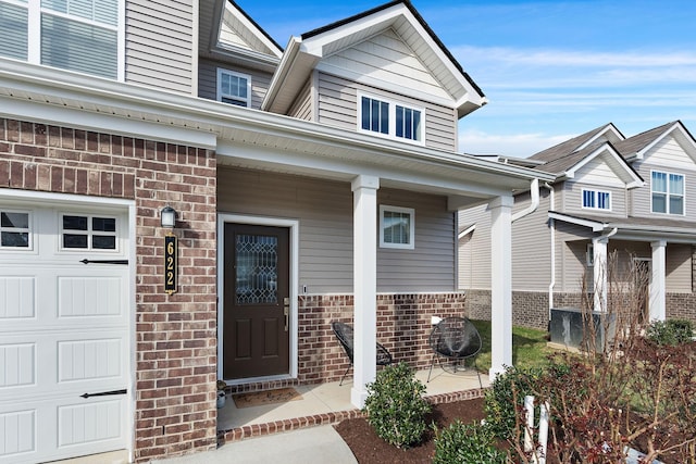 622 Birdie Dr, Spring Hill, TN 37174 - doorway to property with covered porch, a garage, and brick siding