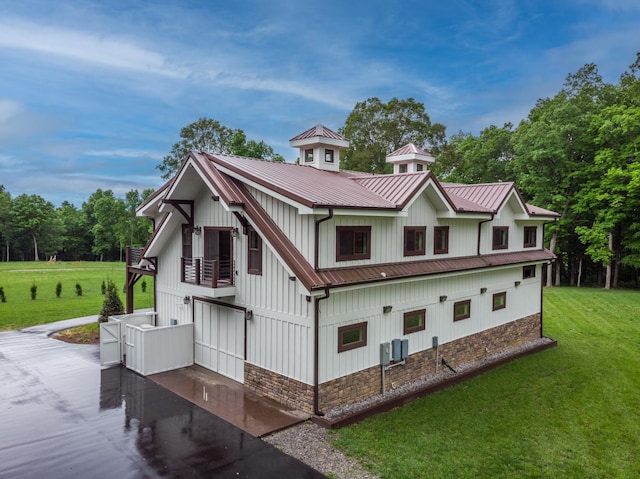 1224 Hangar Dr, Springfield, TN 37172 - view of front of house with a balcony, a front lawn, stone siding, and a metal roof