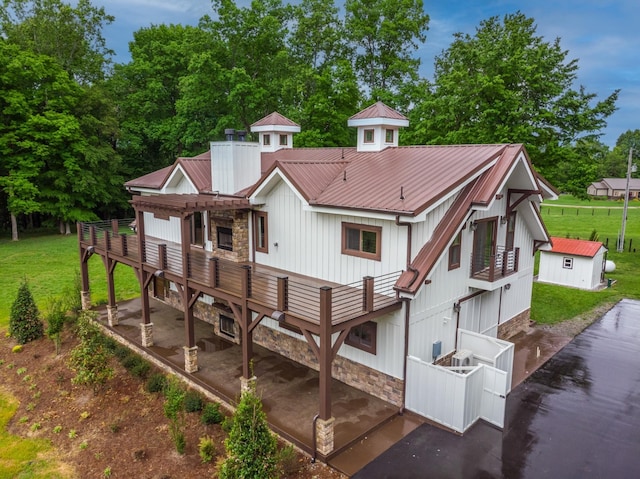 1224 Hangar Dr, Springfield, TN 37172 - back of property with stone siding, a metal roof, a wooden deck, and board and batten siding