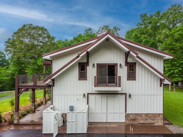 1224 Hangar Dr, Springfield, TN 37172 - back of house featuring a balcony, stone siding, a garage, a lawn, and board and batten siding