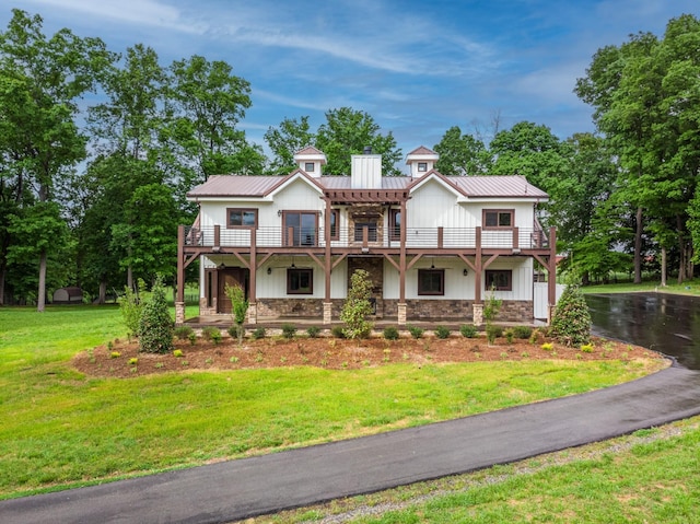 1224 Hangar Dr, Springfield, TN 37172 - view of front facade with a metal roof, a chimney, stone siding, a front lawn, and board and batten siding