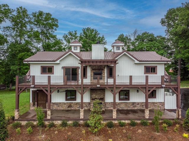 1224 Hangar Dr, Springfield, TN 37172 - back of property featuring stone siding, a balcony, a chimney, a patio, and a metal roof