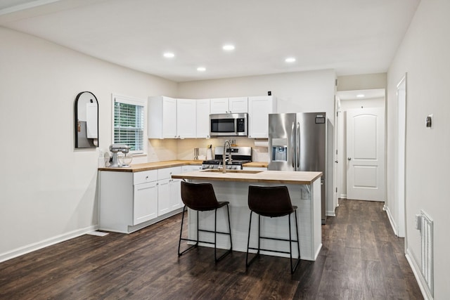 819 Woodside St, Columbia, TN 38401 - kitchen featuring appliances with stainless steel finishes, butcher block countertops, dark wood-style flooring, recessed lighting, and white cabinets