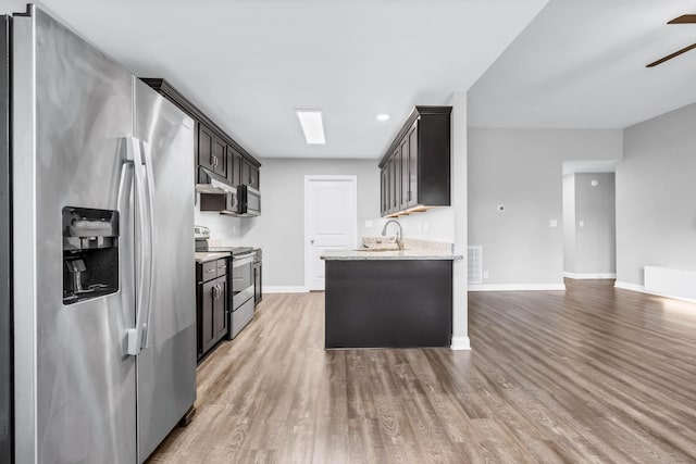 626 Snowshoe Ln, Clarksville, TN 37040 - kitchen with appliances with stainless steel finishes, under cabinet range hood, light wood-type flooring, ceiling fan, and light stone countertops