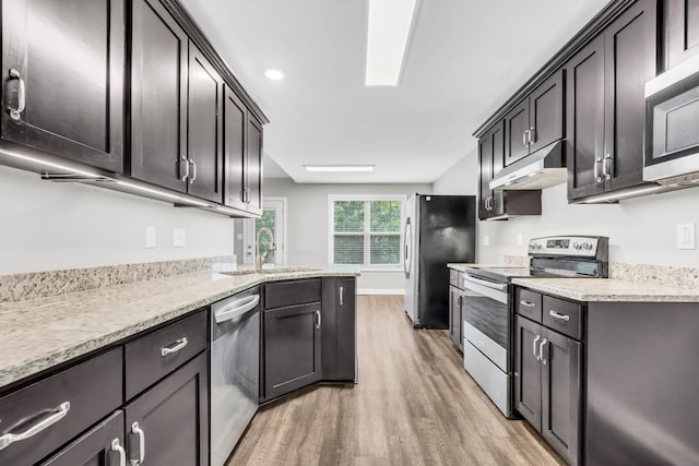 626 Snowshoe Ln, Clarksville, TN 37040 - kitchen with stainless steel appliances, under cabinet range hood, light wood-style floors, and light stone counters