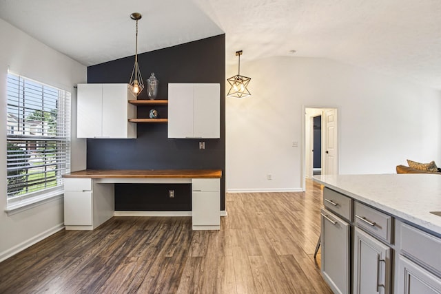 3315 Monoco Dr, Spring Hill, TN 37174 - kitchen with built in desk, vaulted ceiling, open shelves, dark wood-type flooring, and decorative light fixtures
