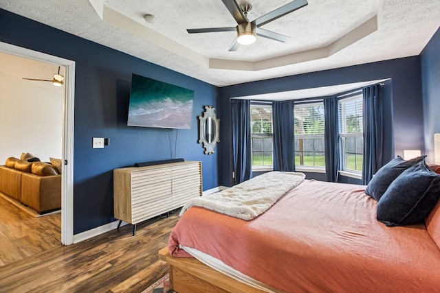 3315 Monoco Dr, Spring Hill, TN 37174 - bedroom featuring a tray ceiling, a textured ceiling, dark wood-style floors, and ceiling fan