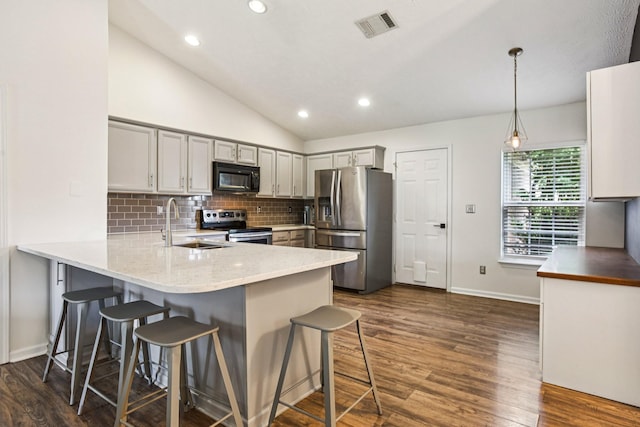 3315 Monoco Dr, Spring Hill, TN 37174 - kitchen with appliances with stainless steel finishes, a peninsula, a breakfast bar area, gray cabinetry, and backsplash