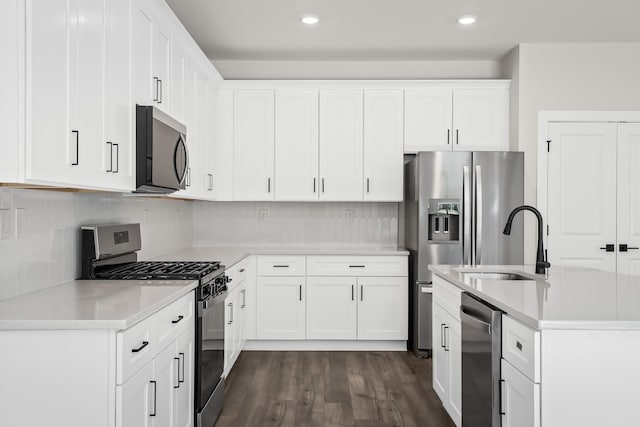4005 Norman Dr, Spring Hill, TN 37174 - kitchen featuring appliances with stainless steel finishes, dark wood-style floors, tasteful backsplash, white cabinetry, and recessed lighting