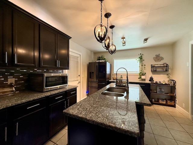 231 Overlook Pl, Columbia, TN 38401 - kitchen featuring stainless steel appliances, light tile patterned flooring, dark stone counters, a kitchen island with sink, and a chandelier