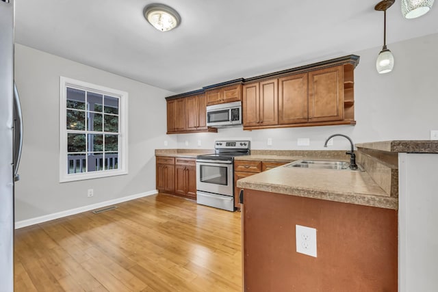 3190 Marthas Chapel Rd, Cunningham, TN 37052 - kitchen with stainless steel appliances, brown cabinetry, open shelves, light wood-style floors, and pendant lighting