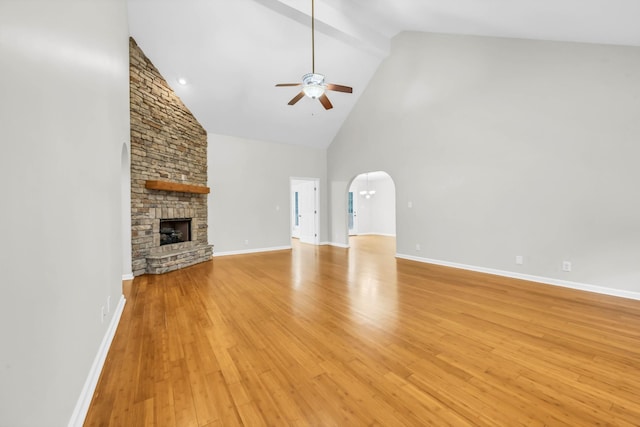 3190 Marthas Chapel Rd, Cunningham, TN 37052 - unfurnished living room with a ceiling fan, high vaulted ceiling, light wood-style flooring, a stone fireplace, and arched walkways