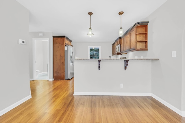 3190 Marthas Chapel Rd, Cunningham, TN 37052 - kitchen featuring appliances with stainless steel finishes, a peninsula, open shelves, light wood-type flooring, and brown cabinets