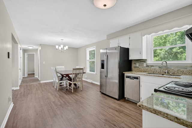 609 Chrisman Dr, Clarksville, TN 37042 - kitchen featuring stainless steel appliances, light wood-style flooring, white cabinets, a chandelier, and decorative backsplash