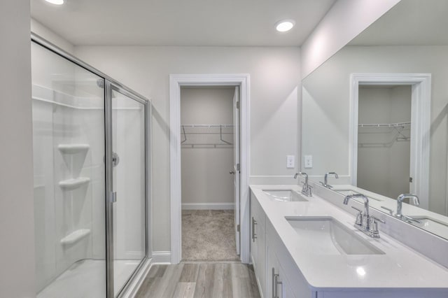1753 Flora Grv, Hermitage, TN 37076 - bathroom with a shower stall, double vanity, a walk in closet, wood finished floors, and recessed lighting