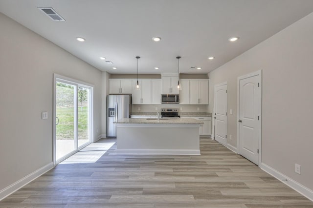 1753 Flora Grv, Hermitage, TN 37076 - kitchen featuring stainless steel appliances, white cabinetry, an island with sink, recessed lighting, and light wood-style floors