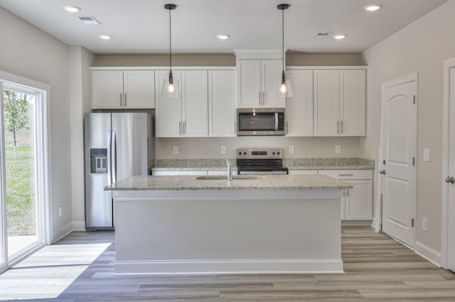 1753 Flora Grv, Hermitage, TN 37076 - kitchen featuring appliances with stainless steel finishes, a kitchen island with sink, white cabinets, light wood finished floors, and recessed lighting