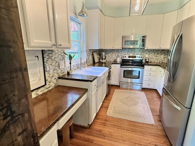 4417 Jackson Hollow Rd, Franklin, TN 37064 - kitchen featuring appliances with stainless steel finishes, dark countertops, hardwood / wood-style floors, and white cabinetry