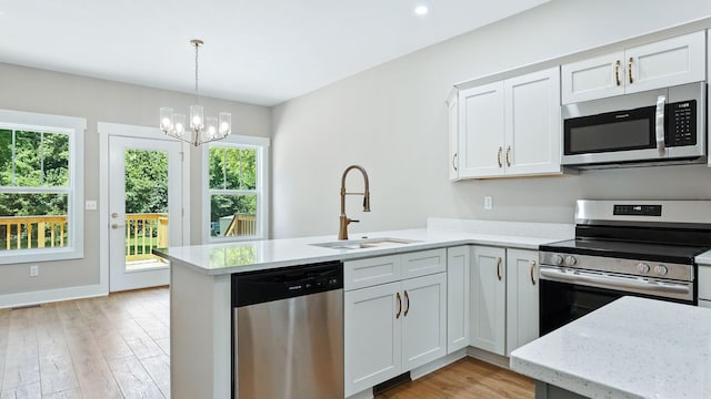 570 Main St S, Ashland City, TN 37015 - kitchen featuring appliances with stainless steel finishes, a peninsula, healthy amount of natural light, and light wood-style flooring