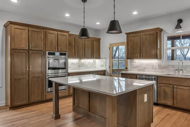 418 Stonemeadow Rd, Clarksville, TN 37043 - kitchen featuring appliances with stainless steel finishes, a center island, recessed lighting, tasteful backsplash, and light wood-style floors