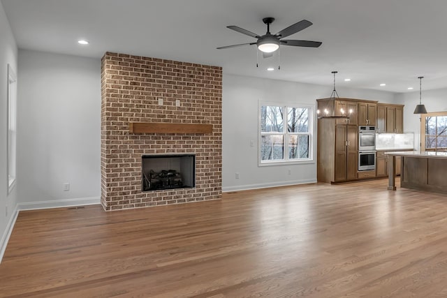 418 Stonemeadow Rd, Clarksville, TN 37043 - unfurnished living room with light wood-style floors, recessed lighting, a ceiling fan, and a fireplace