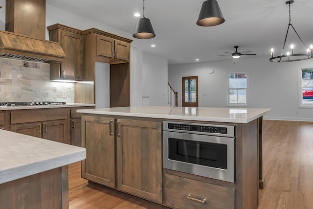 418 Stonemeadow Rd, Clarksville, TN 37043 - kitchen featuring custom range hood, appliances with stainless steel finishes, light wood-style flooring, light countertops, and recessed lighting