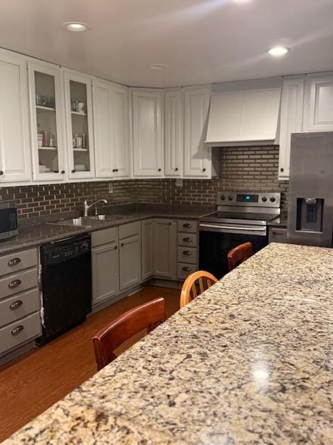 102 Thorogood St, Cowan, TN 37318 - kitchen with appliances with stainless steel finishes, custom range hood, white cabinets, light stone counters, and glass insert cabinets