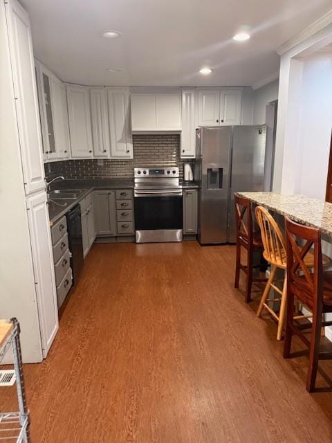102 Thorogood St, Cowan, TN 37318 - kitchen featuring appliances with stainless steel finishes, dark wood-type flooring, white cabinets, glass insert cabinets, and backsplash