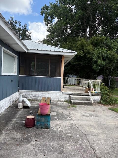 102 Thorogood St, Cowan, TN 37318 - view of property exterior with a sunroom, a metal roof, a patio area, and a deck