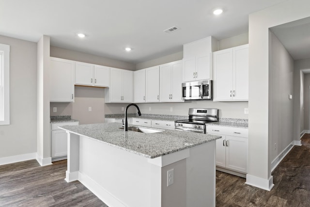 15 Aurora Cir, Fayetteville, TN 37334 - kitchen with stainless steel appliances, dark wood finished floors, a center island with sink, white cabinetry, and light stone countertops