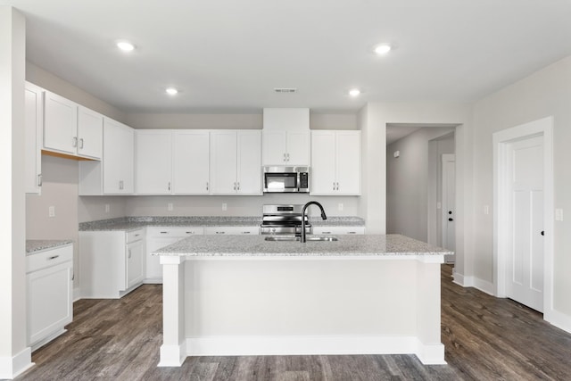 15 Aurora Cir, Fayetteville, TN 37334 - kitchen featuring appliances with stainless steel finishes, dark wood-style floors, an island with sink, light stone counters, and recessed lighting
