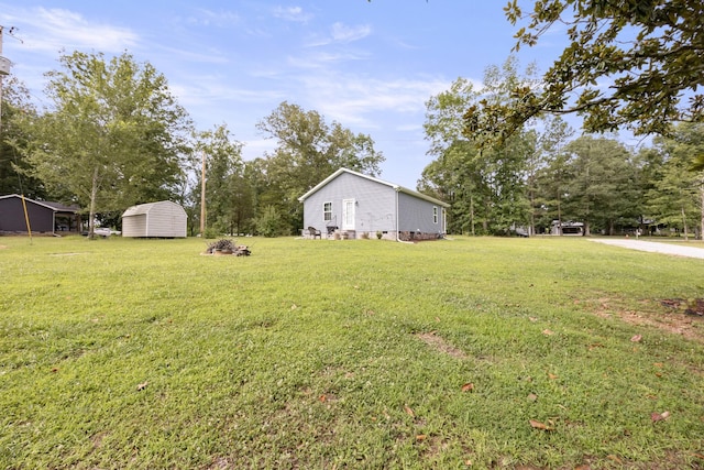 332 Riddle Ln, Estill Springs, TN 37330 - view of green lawn featuring a storage shed, view of wooded area, and a carport