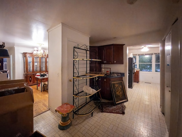 204 Fisher Ave, Carthage, TN 37030 - kitchen featuring brick patterned floors, freestanding refrigerator, a chandelier, dark brown cabinets, and dark countertops