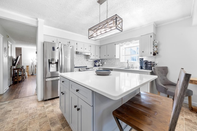 3506 New Windsor Ct, Antioch, TN 37013 - kitchen with appliances with stainless steel finishes, light countertops, a textured ceiling, tasteful backsplash, and a center island
