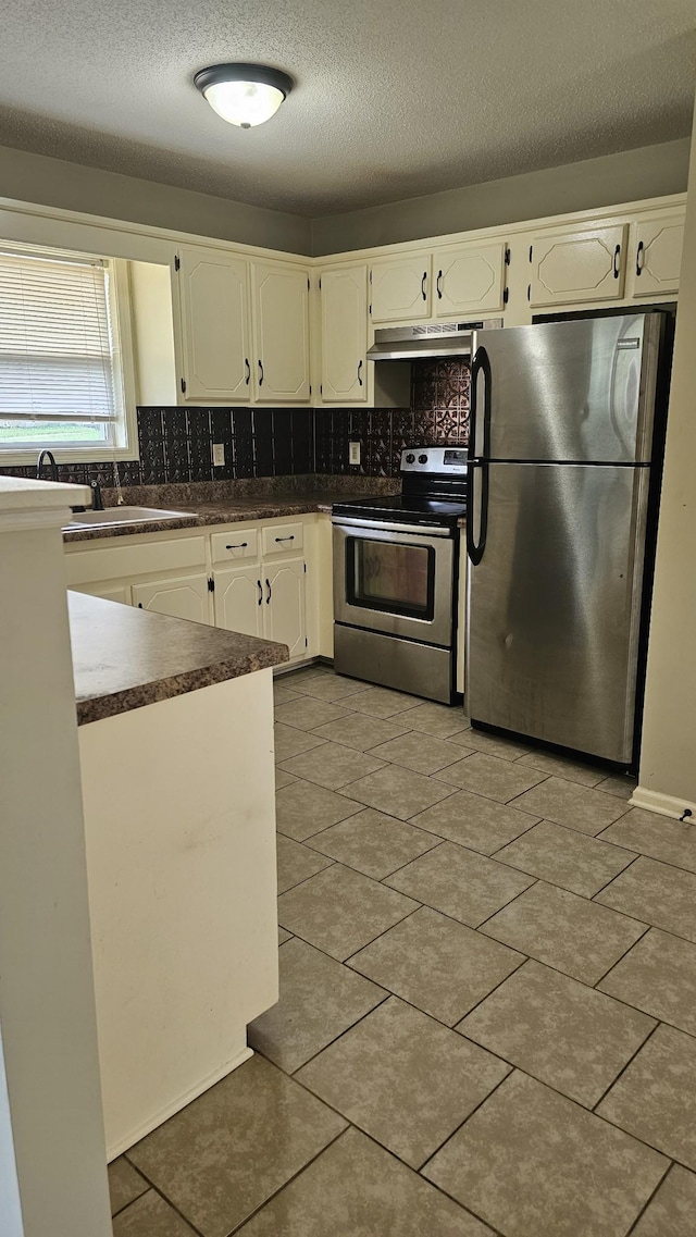 1949 Timberline Cir, Oak Grove, KY 42262 - kitchen featuring appliances with stainless steel finishes, under cabinet range hood, dark countertops, backsplash, and white cabinets
