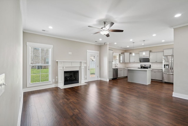 1412 Wrangler Ln, Smyrna, TN 37167 - unfurnished living room featuring a ceiling fan, dark wood-style flooring, recessed lighting, a fireplace with flush hearth, and crown molding