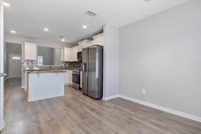215 Ruth Way, Spring Hill, TN 37174 - kitchen with stainless steel appliances, white cabinetry, tasteful backsplash, light wood finished floors, and recessed lighting