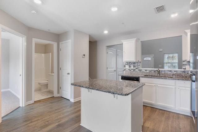 215 Ruth Way, Spring Hill, TN 37174 - kitchen featuring white cabinets, dark stone counters, wood finished floors, a kitchen island, and a kitchen breakfast bar