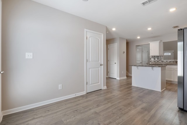 215 Ruth Way, Spring Hill, TN 37174 - kitchen with a kitchen breakfast bar, white cabinets, light wood-style flooring, recessed lighting, and decorative backsplash