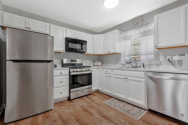 109 Saint Margarett Cir, Columbia, TN 38401 - kitchen with appliances with stainless steel finishes, white cabinets, light countertops, and light wood-style floors
