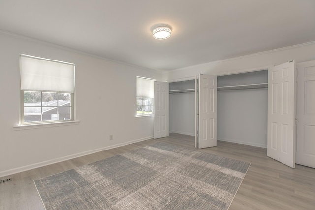 1002 E Northfield Blvd Unit A102, Murfreesboro, TN 37130 - unfurnished bedroom with multiple closets, crown molding, and light wood-style flooring